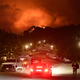 Flames from the Palisades Fire glow in the distance in Topanga, northwest of Los Angeles, May 15, 2021. A brush fire near Pacific Palisades started Friday and grew to 750 acres Saturday night, triggering a mandatory evacuation of residents in the Topanga area.
